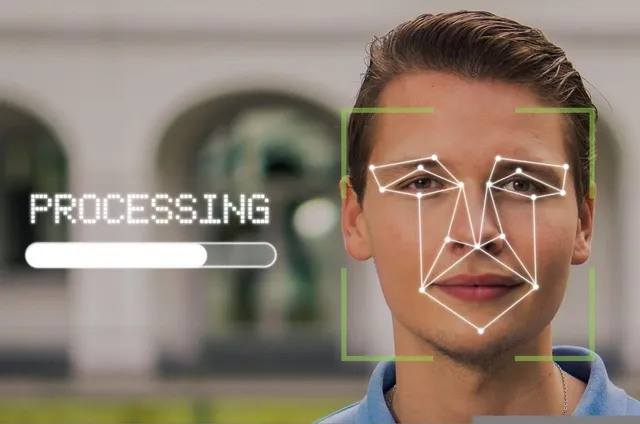 Un bărbat este scanat cu o interfață digitală care afișează linii geometrice pe fața sa și un indicator de procesare pe fundalul blurat.
