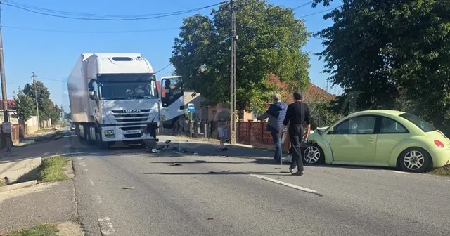 Un autotren alb și un autoturism galben sunt parcate pe marginea unui drum asfaltat sub un cer senin.