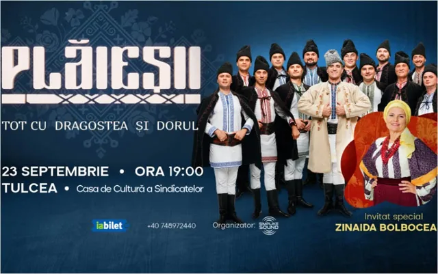 Un grup de bărbați în costume tradiționale albe și negre stă în picioare lângă o femeie îmbrăcată în haine populare colorate pe un fundal albastru.