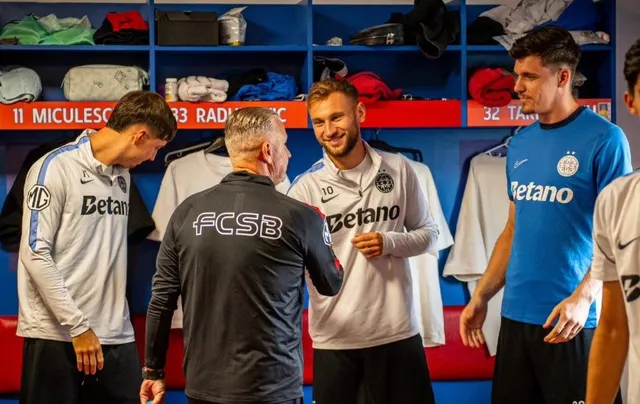 Patru bărbați stau într-o cameră de vest, trei purtând tricouri cu inscripții și unul purtând un hanorac negru cu textul FCSB.