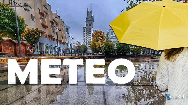 O persoană cu un umbrelă galbenă stă pe o stradă umedă cu clădiri și un turn înalt în fundal.
