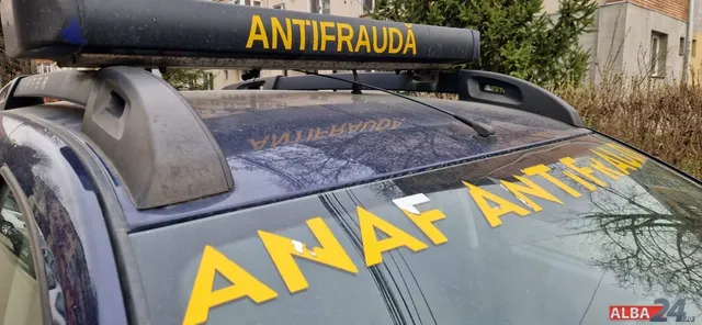 Un vehicul de culoare închisă prezintă inscripții galbene pe parțișul frontal și pe o bară de susținere montată pe plafonul mașinii.