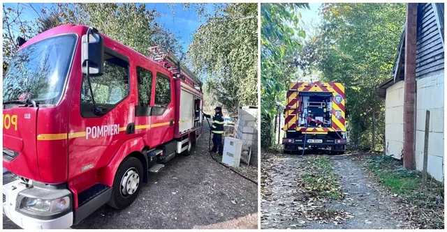 Un camion de pompieri roșu este parcat pe un drum, iar în partea dreaptă se vede spatele unui vehsil de intervenție galben și albastru.