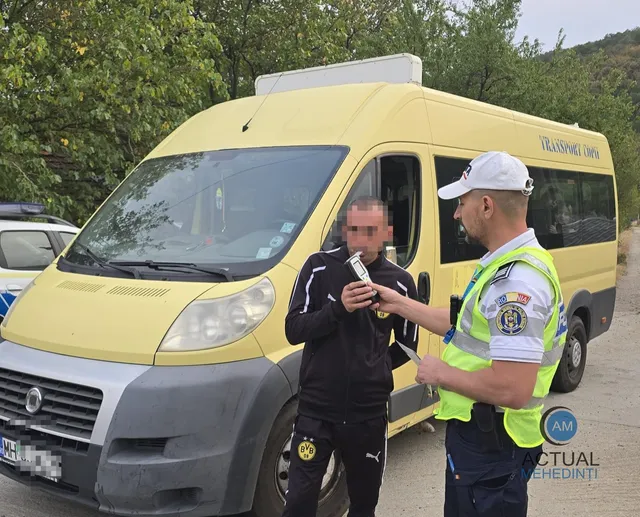 Un polițist în uniformă, cu vestă reflectorizantă, testează un bărbat cu un etilotest, lângă un microbuz școlar galben.