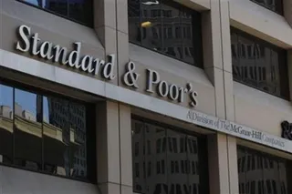 Un semn cu textul Standard & Poor's este montat pe fațada unei clădiri de lângă ferestre întunecate.