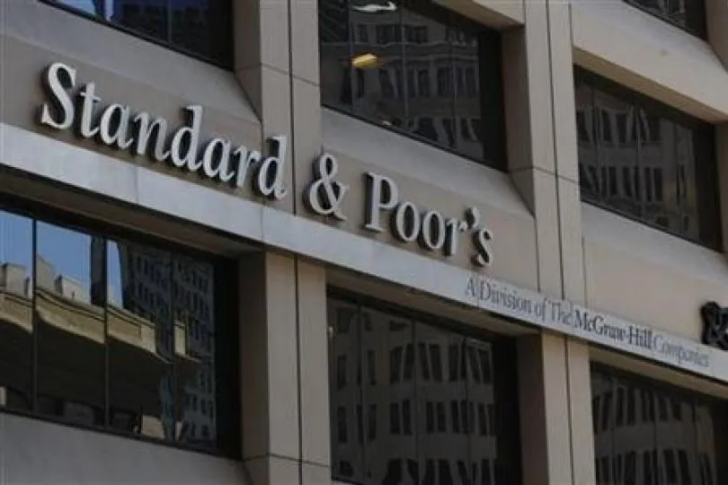 Un semn cu textul Standard & Poor's este montat pe fațada unei clădiri de lângă ferestrele întunecate.