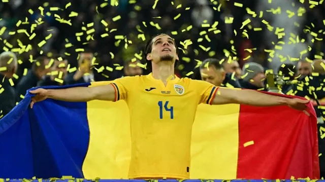 Un bărbat cu o cămașă galbenă marcată cu numărul 14 ține un steag tricolor cu brațele întinse sub ploaie de confetti galbeni.