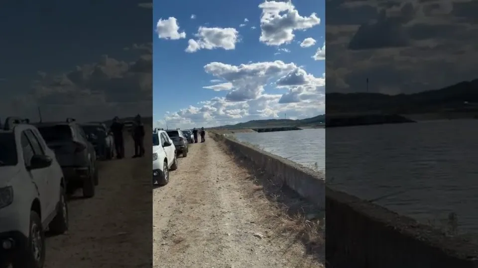 Cadre laterale întunecate încadrează o scenă centrală cu autoturisme parcate pe malul unui fluviu sub cerul albastru.