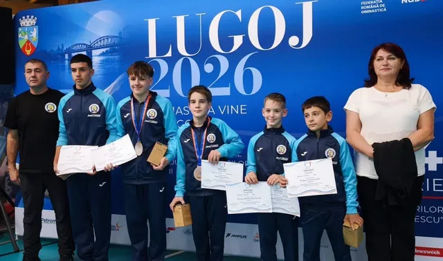 Șase persoane stau în linie în fața unui panou albastru, purtând medalii, diplome și trofee.