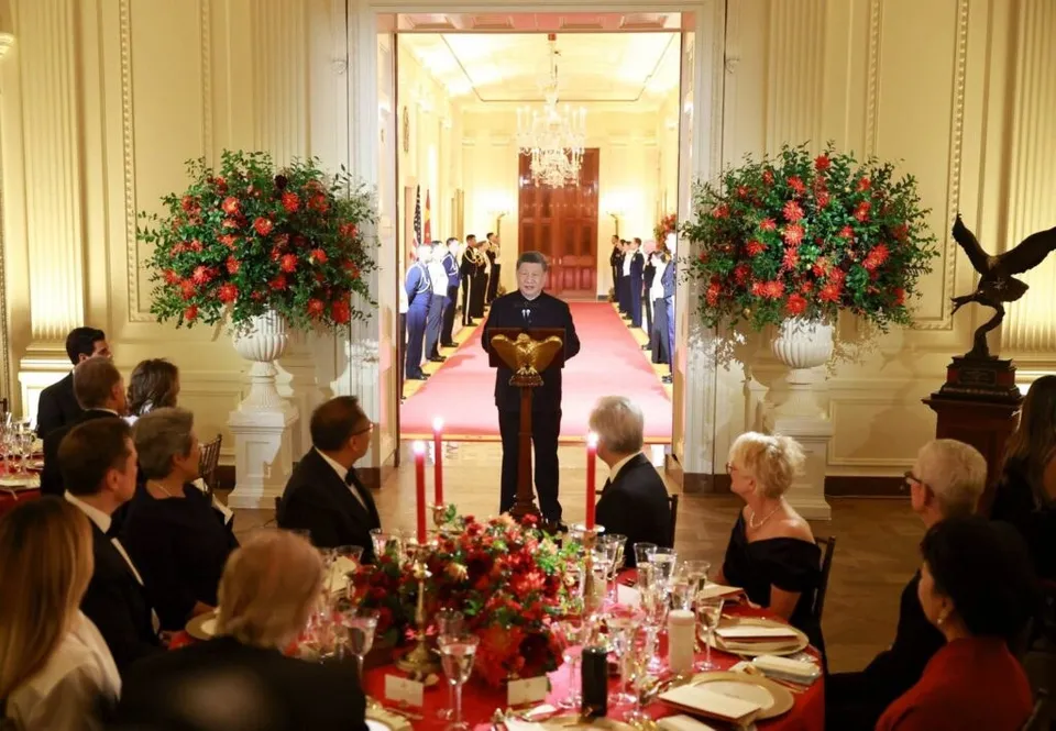 Donald Trump și Xi Jinping apar la o cină de stat într-un salon elegant, în fața unor mese cu floră și lumânări.