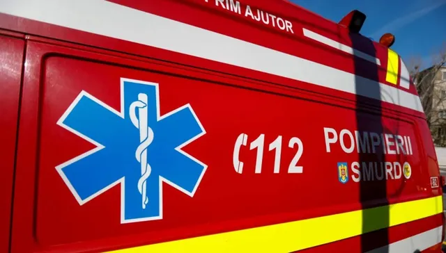 A close-up of a red Romanian emergency vehicle (Pompiers Smurd) showing the blue Star of Life emblem, the emergency number 112, and reflective stripes.