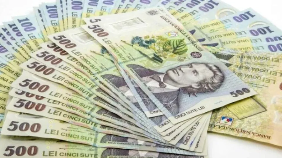 Mai multe bancnote de 500 de lei românești sunt întinse pe o suprafață albă.