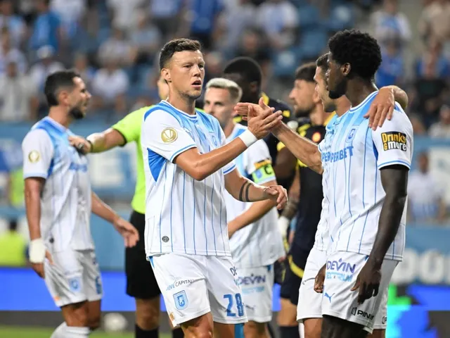 Câțiva jucători de fotbal în echipamente alb-albastre stau pe teren, unii apropiindu-se pentru a se strânge în mână.