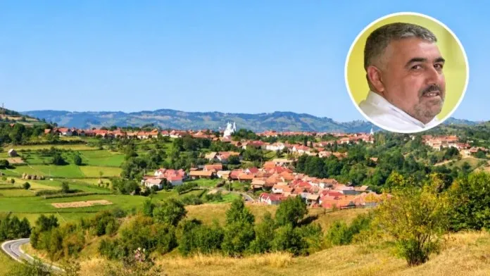 O vedere panoramică asupra unui sat cu case cu acoperișuri roșii, situat pe un deal verde sub un cer senin, cu un portret circular în colțul de sus.