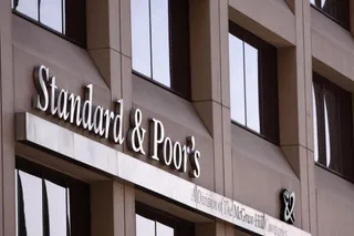 Un semn cu textul Standard & Poor's este montat pe fațada unei clădiri de lângă ferestrele întunecate.