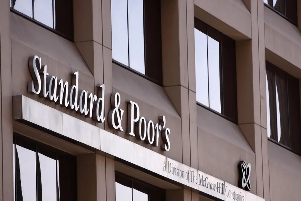 Un semn cu textul Standard & Poor's este montat pe fațada unei clădiri de lângă ferestre întunecate.