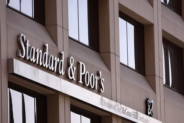 Un semn cu textul Standard & Poor's este montat pe fațada unei clădiri de birouri cu ferestre mari și negre.