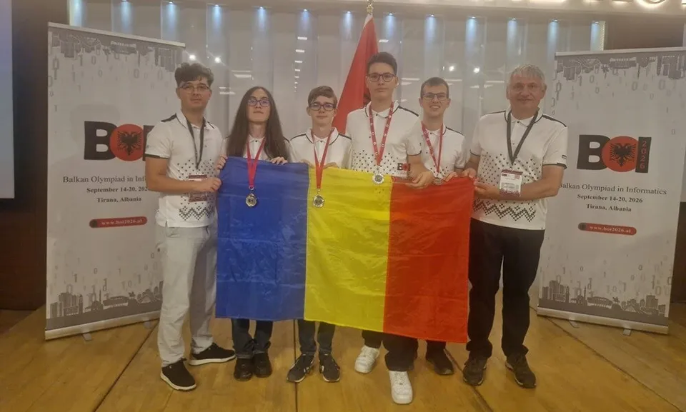 Șase persoane stau în rând pe un podium, purtând medalii și ținând un steag format din trei culori verticale: albastru, galben și roșu.
