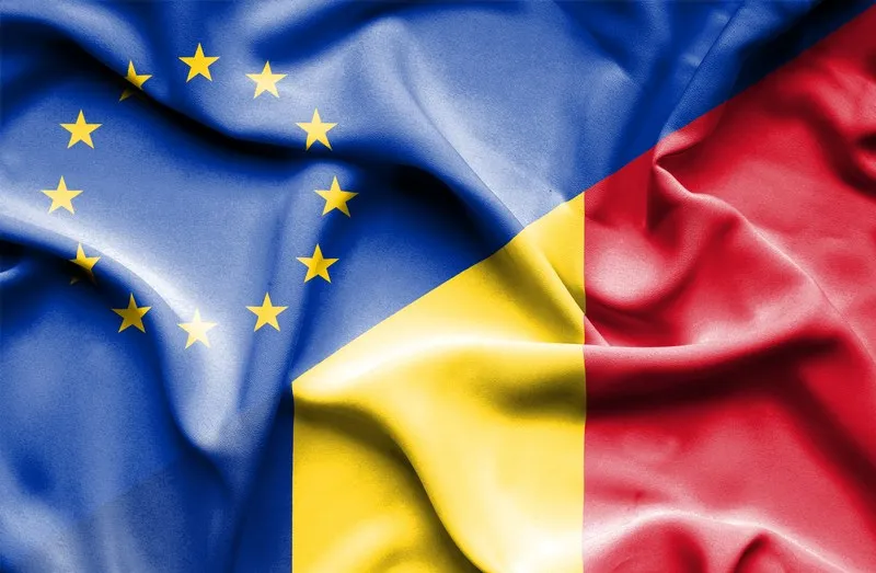 O imagine cu drapelul Uniunii Europene și drapelul României prezentate sub formă de textură de material ondulat.
