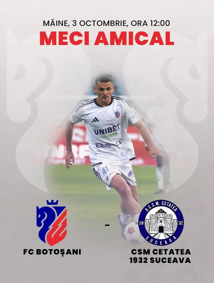 Un jucător de fotbal îmbrăcat în echipament albal de sport rulează pe un teren de fotbal.