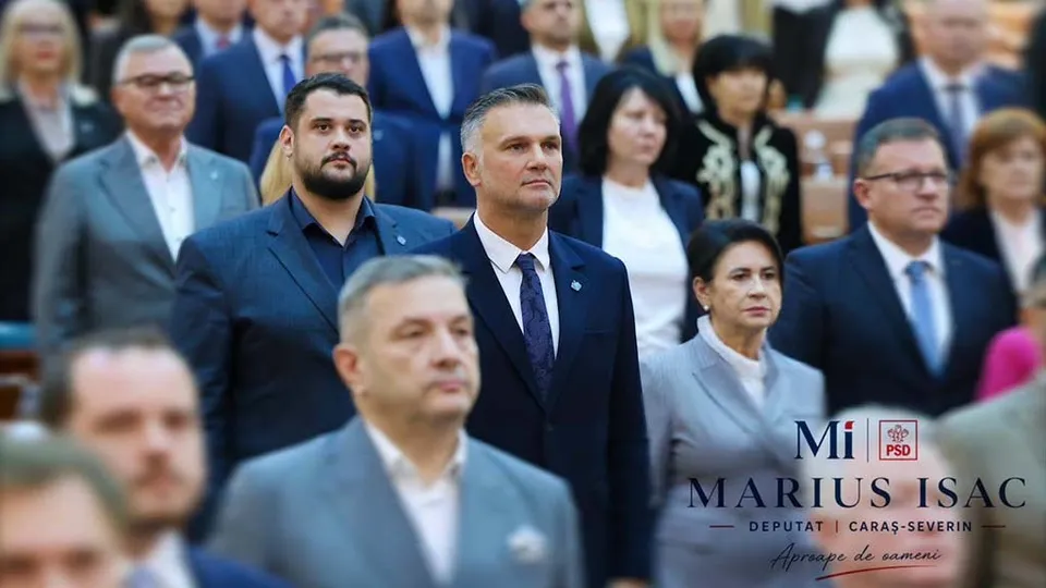 Un grup de persoane îmbrăcate în costume și haine formale stau în picioare într-o încăpere cu scaune din lemn.