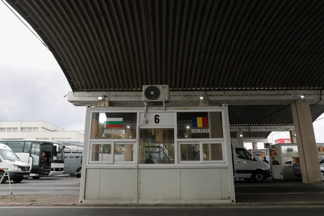 O cabină albă cu ferestre sub un acoperiș metalic mare prezintă steagurile Bulgariei și României pe geamurile sale.