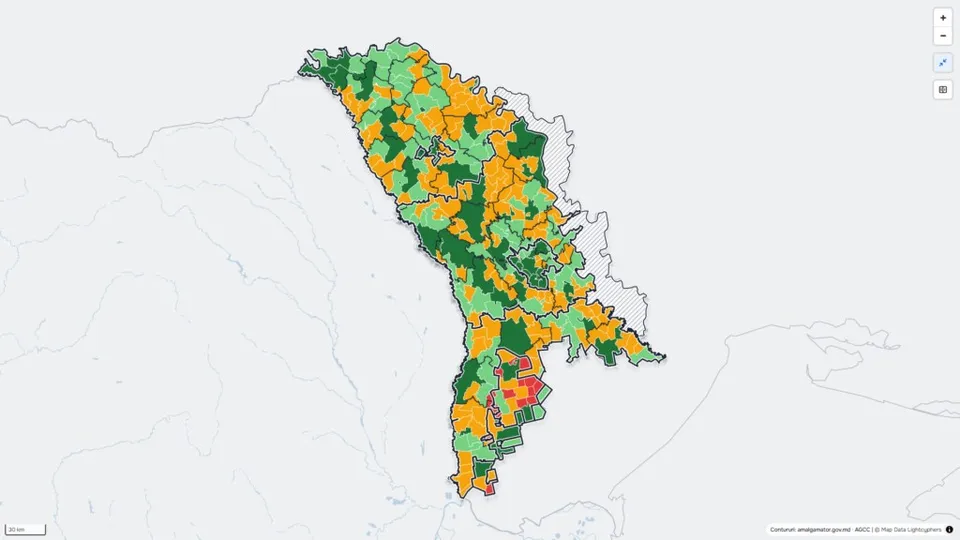 O hartă colorată cu zone verzi, portocalii și roșii este suprapusă pe conturul unei regiuni geografice pe un fundal gri deschis.