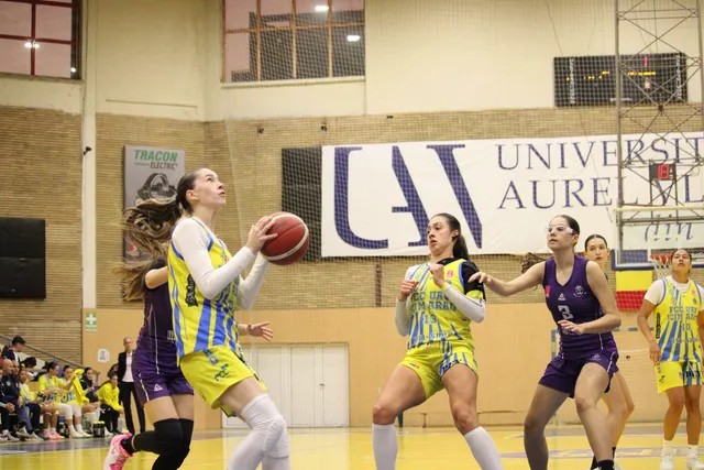 Câteva femei în echipamente sportive de baschet sunt pe un teren de joc, în timp ce una dintre ele ține o minge de baschet.