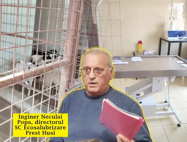 Un bărbat cu ochelari și un dosar roz stă în fața unei mese metalice și a unei cuști cu câini.