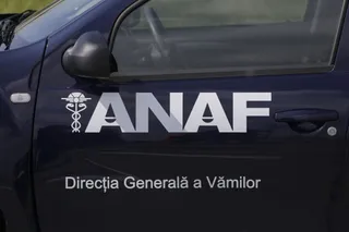 Un autovehicul de culoare închisă prezintă inscripția ANAF și textul Direcția Generală a Vămilor pe portiera laterală.