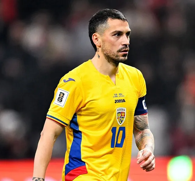 Un bărbat cu barbă și tatuaje pe braț poartă un tricou galben cu detalii albastre și roșii, având numărul zece imprimat pe piept.
