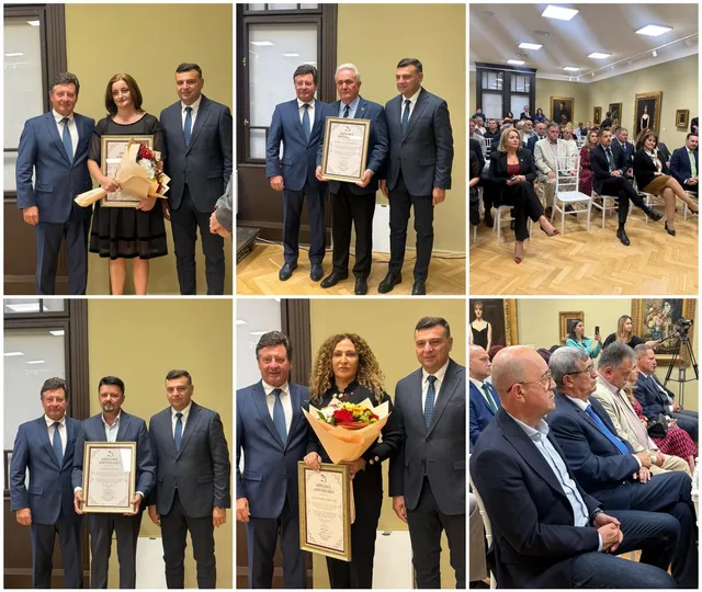 Un grup de bărbați în costume și o femeie cu un buchet de flori stau în picioare în fața unui perete deschis.