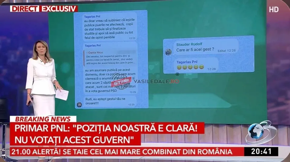 O femeie într-o ținută albă stă în fața unui ecran mare care afișează mesaje de tip chat și un titlu de știri.