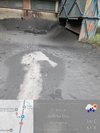 O săritură de vopsea albă sub formă de săgeată este pictată pe un sol acoperit de un strat de material negru și granular.