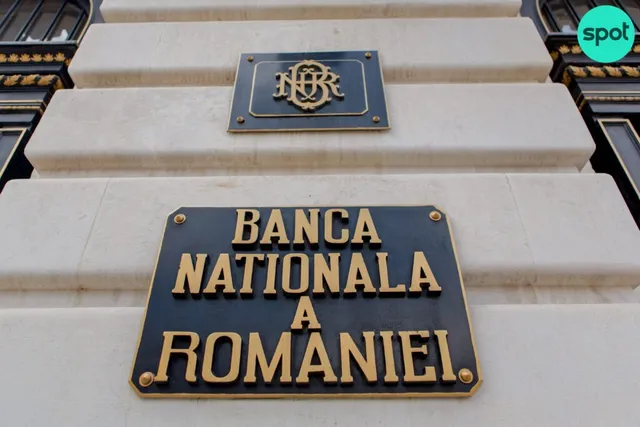Plăcuță neagră cu textul BANCA NATIONALA A ROMANIEI scris cu litere aurii, montată pe trepte de piatră deschise la culoare.