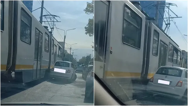 Un tramvai alb cu o dungă galbenă este poziționat lângă un autoturism alb pe o stradă cu vegetație și stâlpi de iluminat.