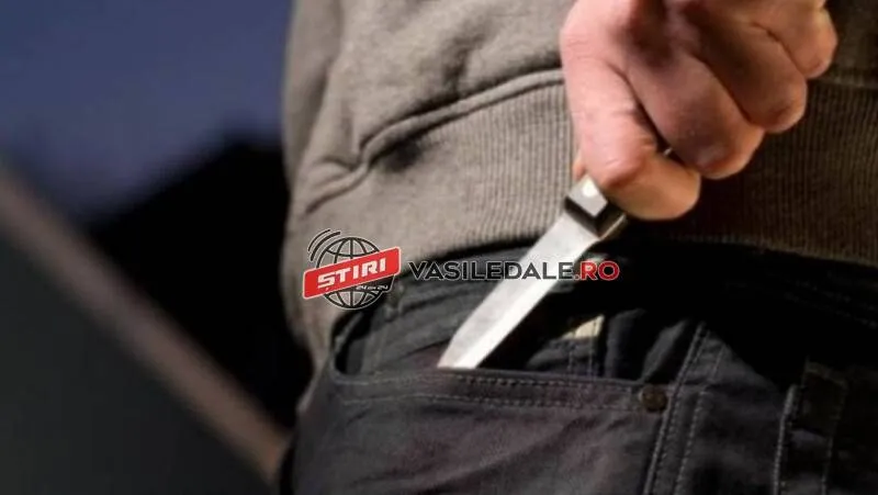 Un bărbat poartă un obiect metalic cu mâner în buzunarul de la pantaloni, fiind ținut de mâini.