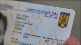 O carte de identitate cu textul CARTE DE IDENTITATE și un scut colorat este ținută de o mână.