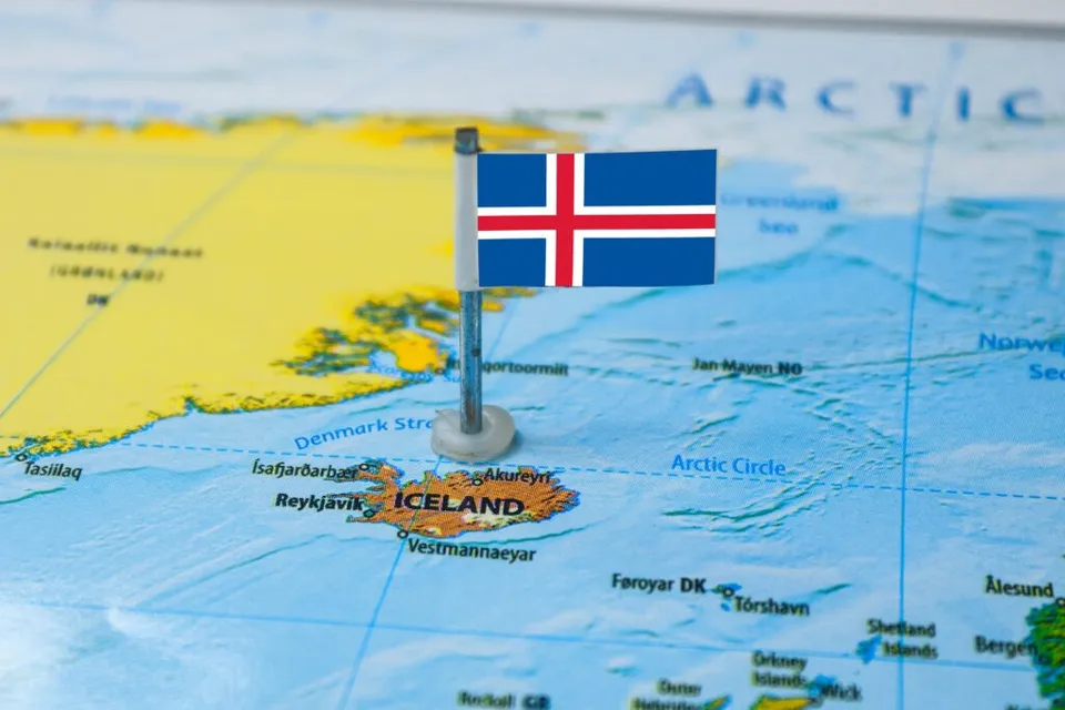 O mică steag al Islandei este fixat pe o hartă care indică Oceanul Arctic și regiunea Islandei.
