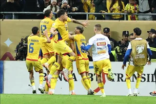 Cei șase jucători de fotbal îmbrăcați în echipamente galbene sărbătoresc pe terenul de fotbal.
