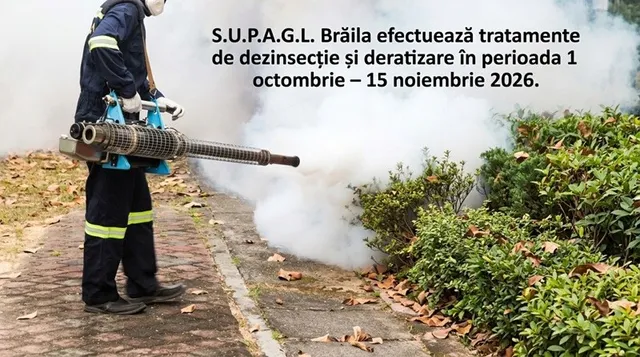 O persoană îmbrăcată în costum de lucru albastru folosește un dispozitiv care scoate fum alb lângă un gard de arbuști verzi.