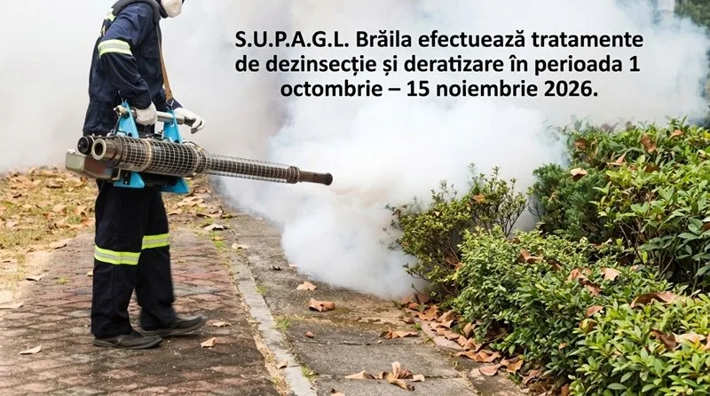 O persoană îmbrăcată în costum de lucru albastru folosește un dispozitiv care scoate fum alb lângă un gard de arbuști verzi.