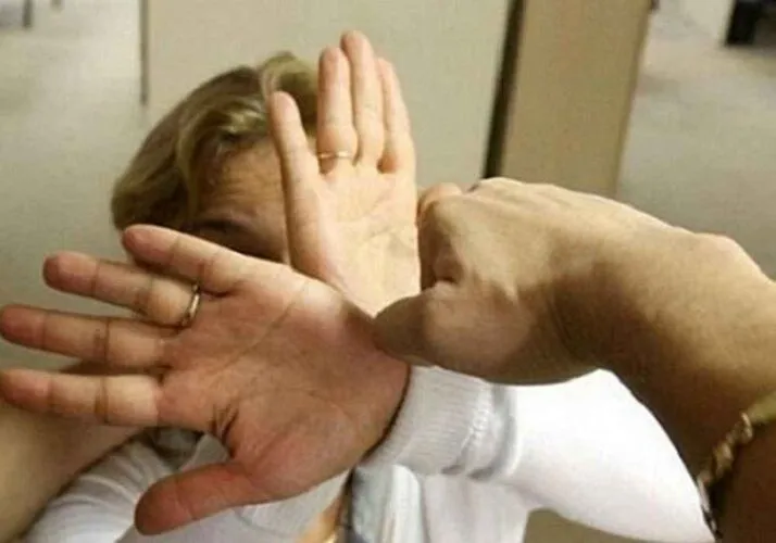 O persoană în haine albe ridică ambele mâinile cu palmele în afară în poziție de apărare.