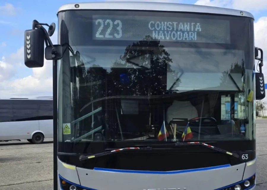 Imaginea arată partea frontală a unui autobus modern cu ecranul de afișare pe care se citește numărul liniei 223 și destinația CONSTANȚA NĂVODARI.