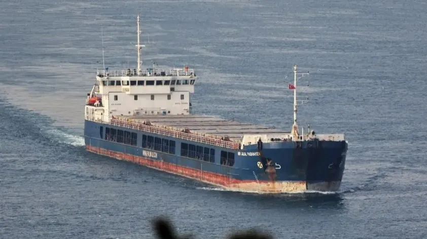 Un vapor de mare cu suprafață albă și albastră navighează pe o apă de culoare închisă.
