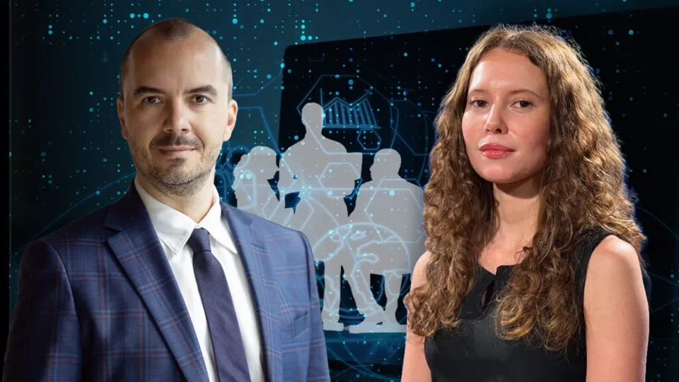 Un bărbat cu sacou și cravată stă lângă o femeie cu părul lung și creț în fața unui ecran digital cu siluete umane.