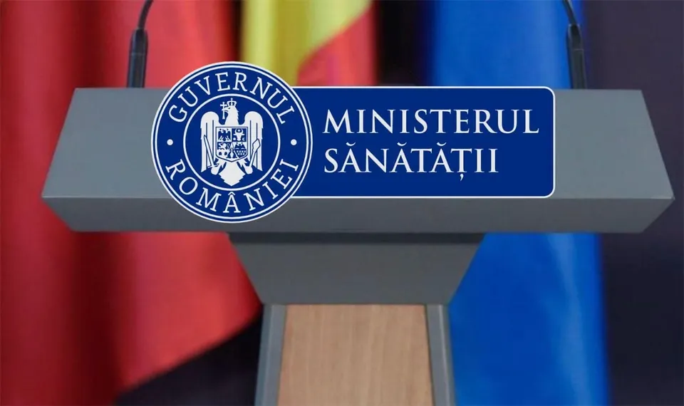 Un podium gri cu emblema Guvernului României și textul Ministerul Sănătății este poziționat în fața unor steaguri colorate.