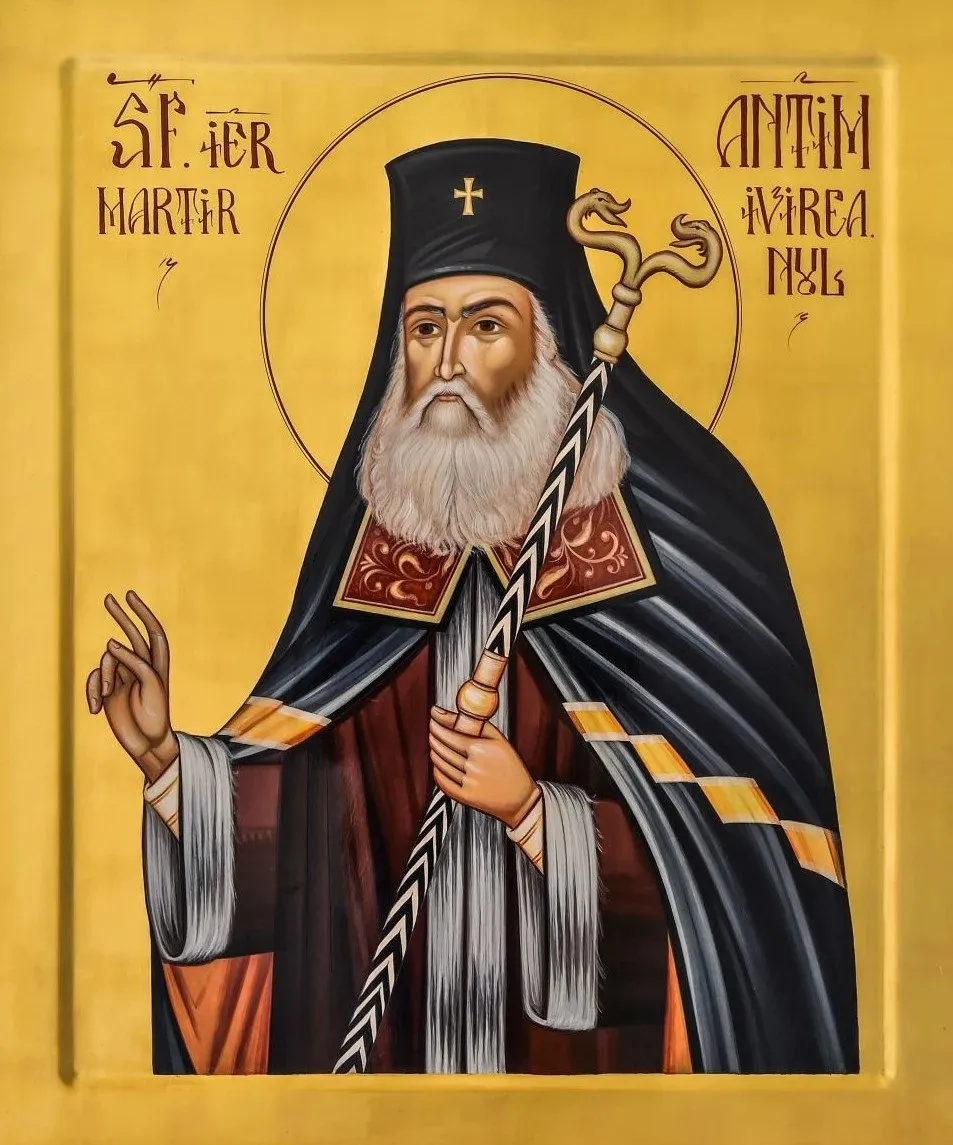 O pictoră ortodoxă ilustrează un ierarh cu barba albă, îmbrăcat în veșminte sacre și ținând un crosier, pe un fundal auriu.