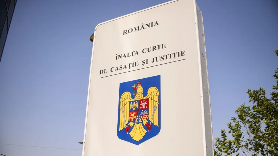 Un semn exterior alb afișează textul ROMÂNIA și ÎNALTA CURTE DE CASATIE ȘI JUSTIȚIE deasupra stemei României pe un fundal albastru.