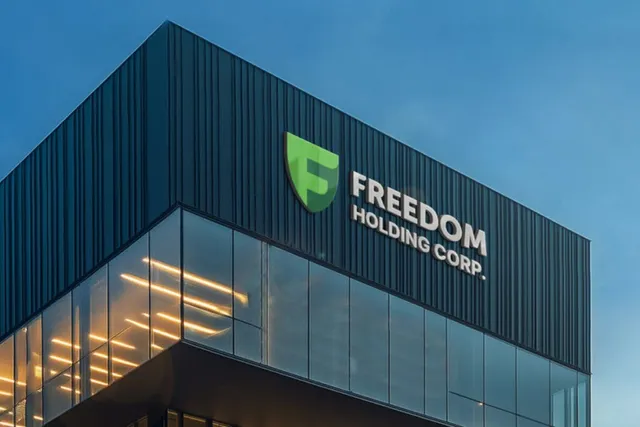 Un clădire modernă cu fațadă închisă la culoare și panouri de sticlă prezintă un logo verde și textul Freedom Holding Corp.